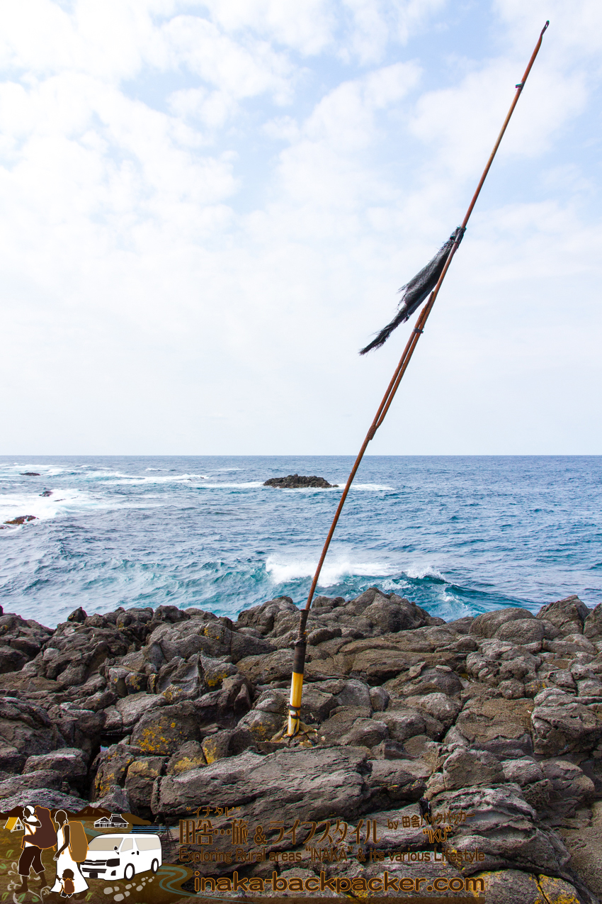 舳倉島の海岸にたつ旗。何の旗だかわからない状態になっていた。