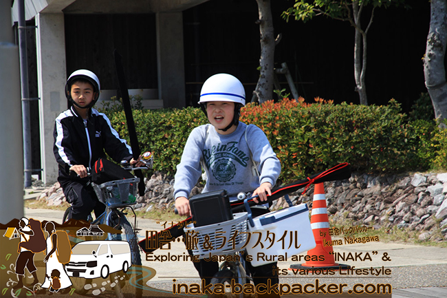 熊本県天草市牛深 – 自転車のかごに釣竿を入れて、「うしぶか海彩館」にやってきた中学生たち。対自然との遊びがごく“普通”の子どもたち